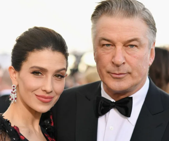 Couple posing at a formal event, woman in elegant dress, man in tuxedo.