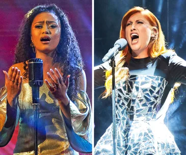 Two women performing passionately on stage; one with curly hair in a gold dress, the other with red hair in a mirrored dress.