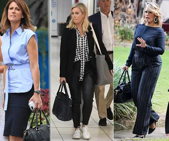 Women walking outdoors, each holding bags and dressed in casual business attire.