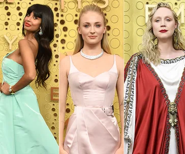 Three women at the 2019 Emmys red carpet in elegant gowns, posing against a gold backdrop.