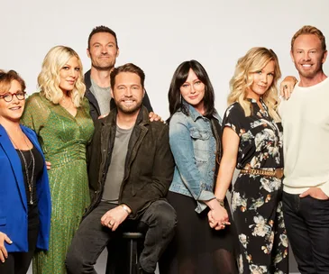 Cast members of the BH90210 reboot pose together against a plain background.
