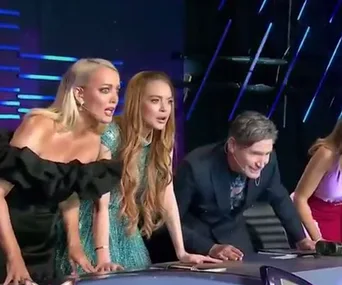 Panel of judges on "The Masked Singer Australia" look surprised, leaning forward at a desk with dramatic lighting.