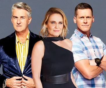 Three individuals posing: a man in a velvet blazer, a woman in a black dress, and a man in a plaid shirt.