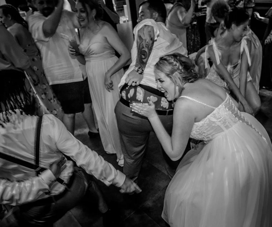 A joyful wedding dance floor scene with guests laughing and enjoying.