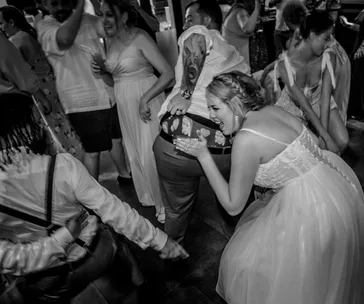 A joyful wedding dance floor scene with guests laughing and enjoying.