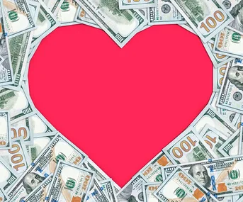 Dollar bills forming a heart shape with a pink center.