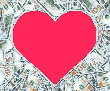 Dollar bills forming a heart shape with a pink center.
