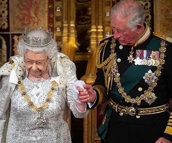 Queen Elizabeth II and a man in military attire at a formal event.