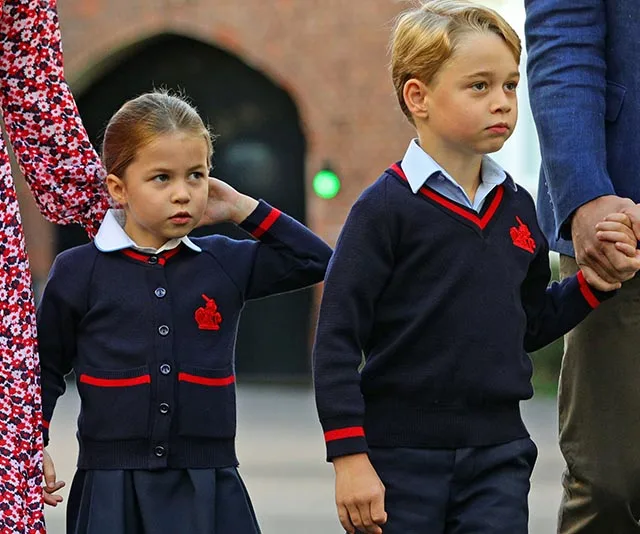 Children in school uniforms walking, with one holding an adult's hand.