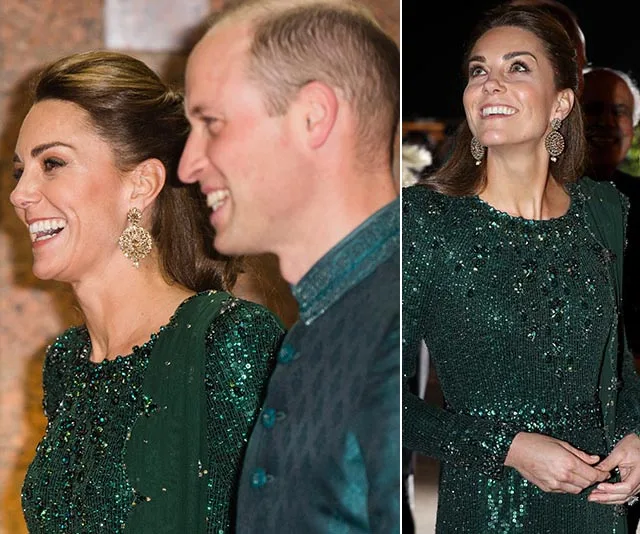 "Person in green sequined dress and dangling earrings, smiling alongside another individual in traditional attire."