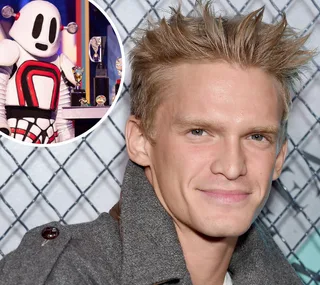 Cody Simpson with a smiling expression; inset shows the Robot costume from The Masked Singer.