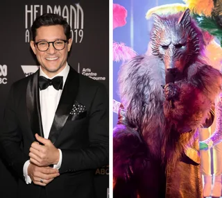 Rob Mills at an event in a tuxedo next to a person in a wolf costume on a colorful stage.