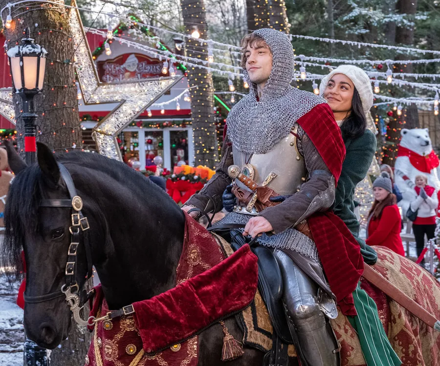 A knight and woman in winter wear ride a black horse at a festive Christmas market decorated with lights and a polar bear statue.
