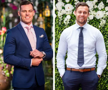Two men in suits, one in a blue suit and pink tie, the other in a striped shirt and tie, posing in front of flowers.