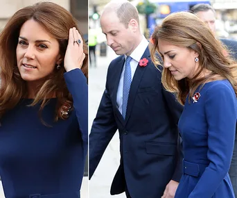Kate Middleton in a blue dress with earrings, walking outdoors with Prince William.