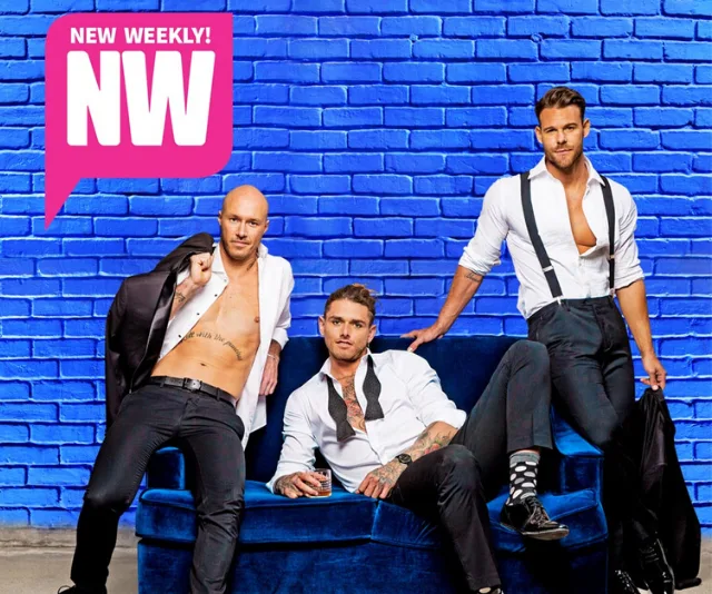 Three men dressed in white shirts and suspenders pose against a blue brick wall with a "New Weekly" logo.