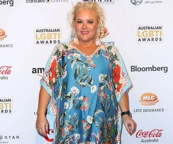 I don't know who this is, but it's someone at an event wearing a floral dress, standing in front of an Australian LGBTI Awards banner.