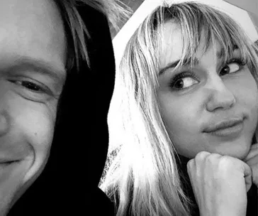 Two people smiling in a black and white selfie.