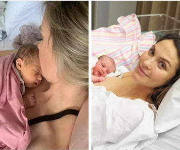 Mother holding newborn baby in hospital bed, wrapped in pink blankets, both looking peaceful and content.