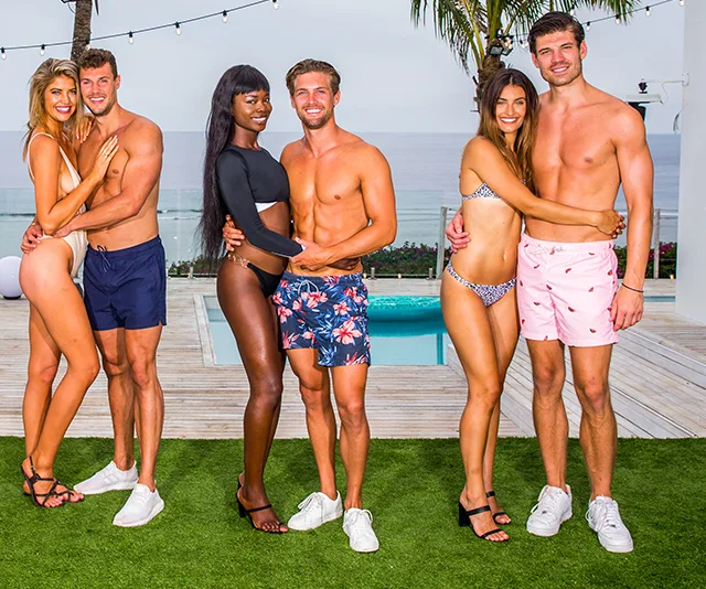 Contestants of Love Island Australia 2019 standing in swimwear by a poolside, embracing and smiling.