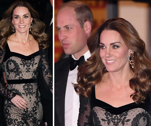 Elegant woman in a black lace gown and man in a tuxedo attending an event together, smiling.