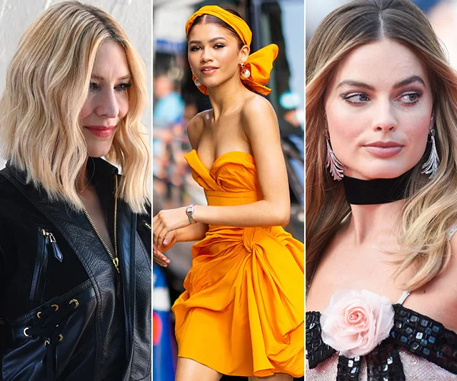 Three women in stylish outfits: one in black leather, another in orange with headband, and the third in a black and pink dress.