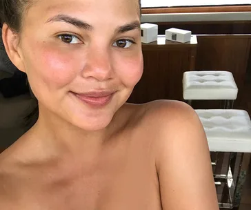 Smiling person with glowing skin, indoors.