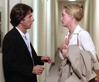 A man and woman face each other in a tense hallway confrontation, holding coats, from "Kramer vs. Kramer."