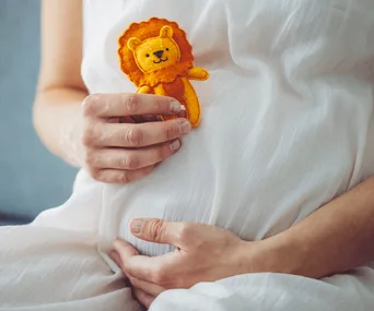 baby’s star sign: Small baby sleeping while holding a cardboard cutout of a moon