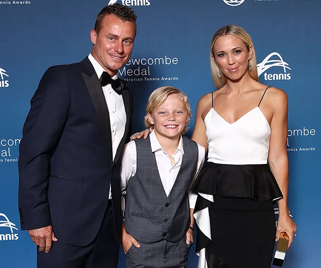 Three people pose at the Newcombe Medal Australian Tennis Awards, smiling against a blue backdrop.