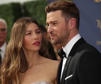 A couple dressed elegantly, attending a formal event, posing for a photo.