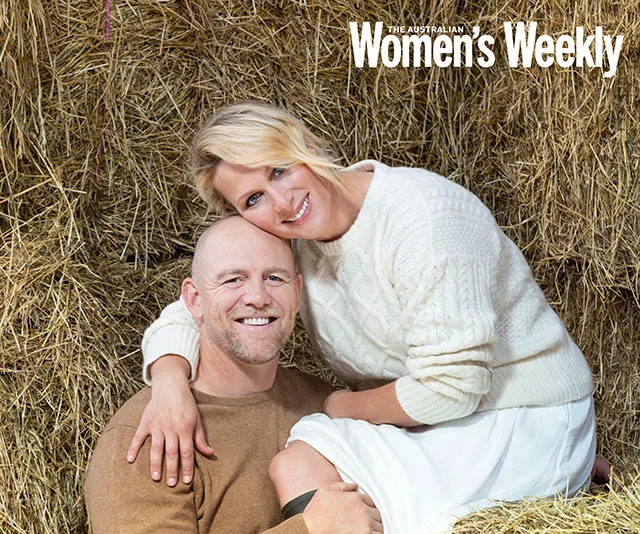 A couple smiling and posing together in front of stacked hay bales for The Australian Women's Weekly cover.