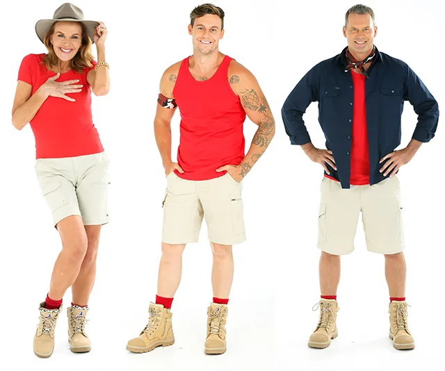 Three people in red shirts and khaki shorts pose confidently for "I'm a Celebrity" promo.