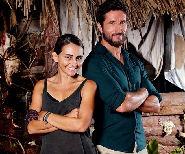 Two contestants from Australian Survivor: All Stars 2020 standing back-to-back in a rustic setting.