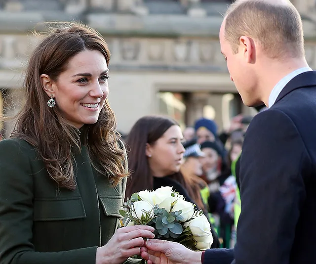 Kate Middleton receives a bouquet from Prince William during a public appearance in Bradford, surrounded by onlookers.