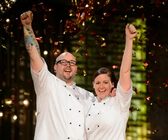 Two chefs celebrate under falling confetti, arms raised in victory, smiling broadly in white uniforms.