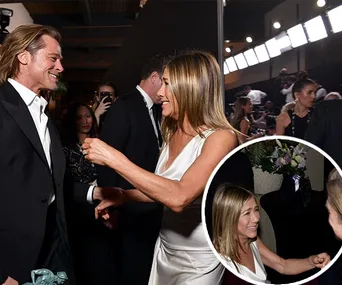 Actors greet and smile at an awards event, with onlookers in the background.