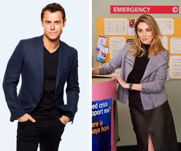 Two people; one in a blue jacket and black shirt, the other in a gray jacket by an emergency sign.