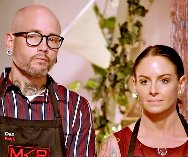 Two contestants from My Kitchen Rules 2020 stand together, wearing aprons, with a focused expression.