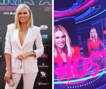 Blonde woman in white suit at ARIA Awards; next to display screen with "HOST" text and her image in the background.