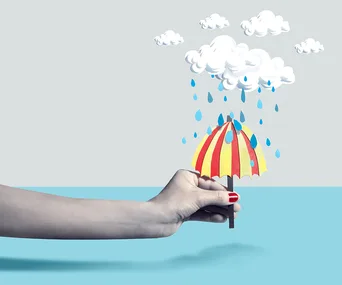 A hand holding a small red and yellow umbrella under illustrated clouds with raindrops against a blue and gray background.