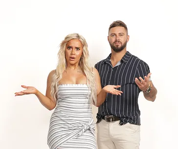 A woman and a man stand side by side with confused expressions, both gesturing with their hands.
