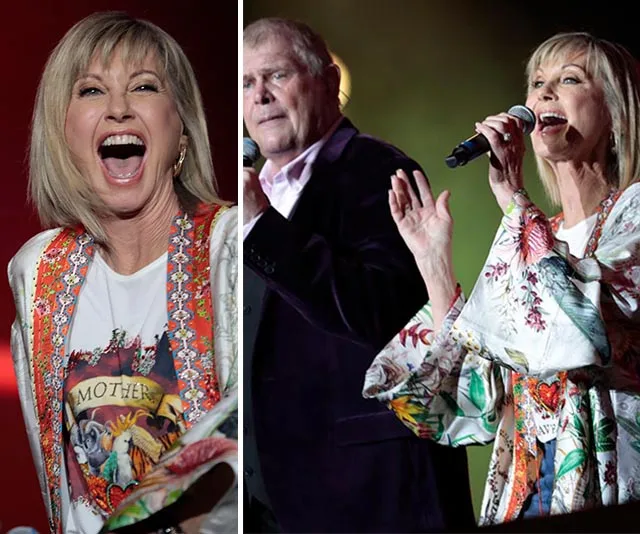 Olivia Newton-John performing energetically on stage with vibrant clothing at a concert.