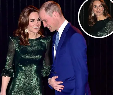A woman in a sparkling green dress stands next to a man in a blue suit, both smiling and engaged in conversation.