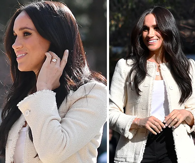 Meghan Markle smiling, wearing a white jacket and dark pants, outdoors during International Women's Day event.