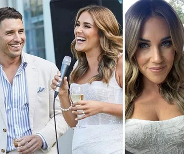 Woman in a white dress smiling with a microphone and a man, holding champagne, at an event.