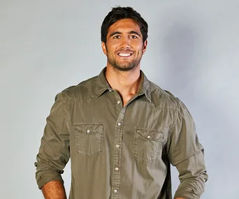 Man in a green shirt smiling against a plain background, likely from "Home and Away".