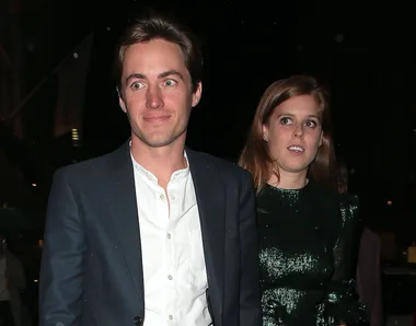 A couple in formal attire walking outdoors at night.