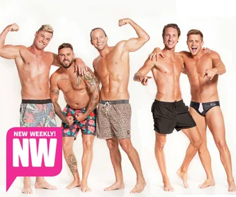 Group of five shirtless men posing confidently in colorful swimwear against a plain background.