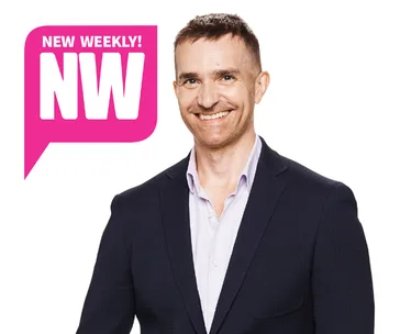 A man in a suit smiles against a white background with a pink "NW" logo on the left.